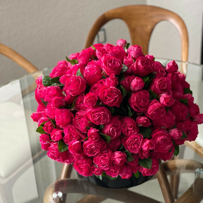 Dunkelrosafarbene englische Rosen in schwarzer Glasvase