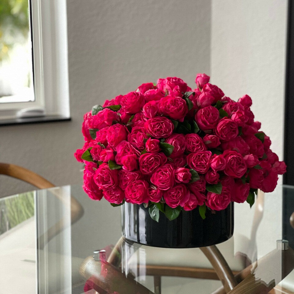 Dunkelrosafarbene englische Rosen in schwarzer Glasvase